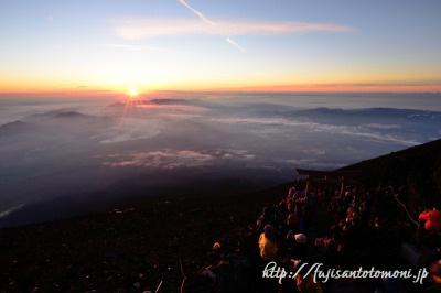 富士山山頂から望む御来光と登山者たち