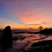 秋谷海岸立石の夕焼けの写真 「蒼の閃光」