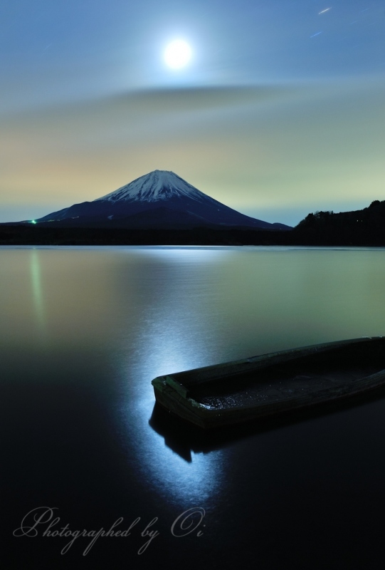 精進湖のボートと月明かりと富士山の写真