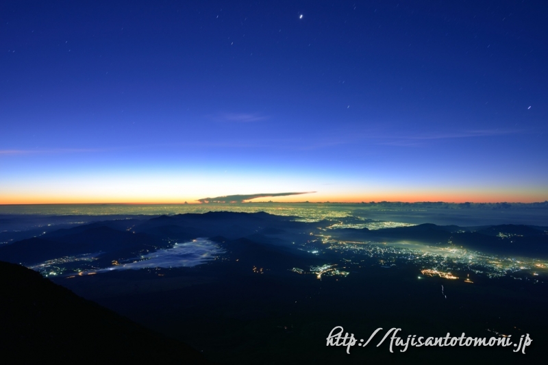 富士山山頂から望む夜景と夜明けの空