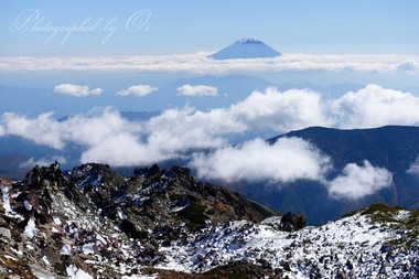 ＜12月＞ 南アルプスにも雪が降った。荒々しい稜線の向こうに富士が顔を出す。  ― 静岡県・南アルプス悪沢岳