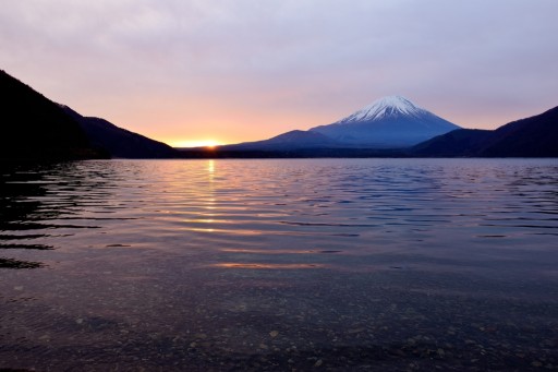 本栖湖から望む御来光と朝焼けの富士山の写真