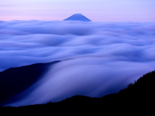 国師ヶ岳の滝雲と富士山の写真
