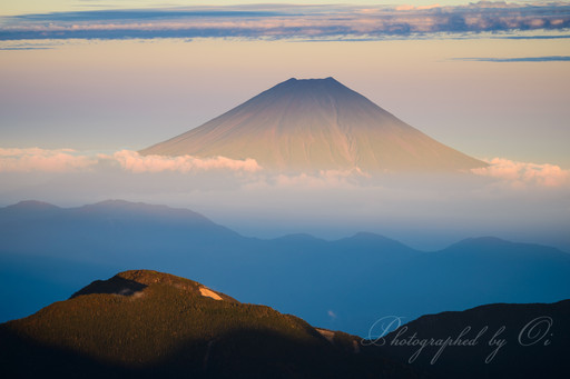南アルプス赤石岳より夕日に染まる富士山の写真