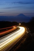 北杜市・中自動車道の光跡と富士山の写真 「夜明けを駆けて」