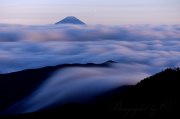 国師ヶ岳の滝雲と富士山の写真 「流れ始める」