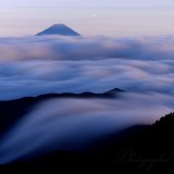 国師ヶ岳の滝雲と富士山の写真 「流れ始める」